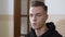 Headshot of sad young Caucasian man talking sitting in psychologist office. Close-up portrait of unhappy stressed male