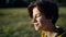 Headshot side view of happy teenage boy with closed eyes enjoying playing musical instrument outdoors. Absorbed