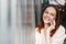 Headshot of smiling female employee with cheerful facial expression, uses smart phone gadget for discussion information with