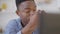 Headshot of tired young handsome man rubbing eyes in slow motion sitting with laptop in home office. Close-up portrait