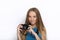 Headshot of young adorable playful blonde woman with cute smile in cobalt color blouse posing with black dslr camera on white back