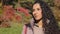 Headshot young attractive young pensive woman standing outdoors in autumn park thinking dreaming calm dreamy girl with