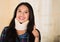 Headshot young hispanic woman posing wearing neck brace, smiling happily giving thumb up to camera, injury concept