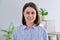 Headshot young smiling woman looking at camera in home interior