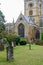 Headstones in cemetery with church behind. Vertical view of memo