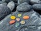 Healing crystals, chakra stones. Rainbow gemstones in a circle on grey volcanic pebbles