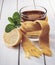 Healing glass of tea in a scarf and lemon on a wooden background