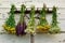 Healing medical herbs on a rake on a white old wooden wall.