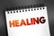 Healing - process of becoming well again, after a cut or other injury, text on notepad concept for presentations and reports