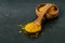Healing spice turmeric powder in wooden spoon and bowl closeup. Anti-inflammatory remedy, immunomodulator