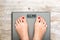 Health and care concept with bulimia word on bathroom scale while a woman is weighting