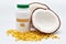 Health care - Nutritional supplement - Bottle of Coconut Oil with halved coconut on the side and scattered gold gel capsule