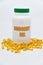 Health care - Nutritional supplement - Bottle of Coconut Oil with scattered gold gel capsule on the front