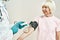 Health Checkup. Doctor in medical uniform and blue sterile gloves measuring blood pressure of senior woman, female