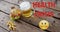 Health Crisis text and  Nauseated Face Emoji against beer, burger and fries on wooden surface