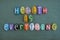 Health is everything, creative slogan composed with multi colored stone letters over green sand