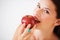 Health, fruit and portrait of woman with apple eating for nutrition, wellness and snack in studio. Food, balance diet