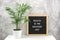 Health is the greatest gift. Motivational quote on letter board on white table and green exotic palm flower in pot, gray stone