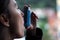 Health and medicine - Young girl using blue asthma inhaler to prevent an asthma attack