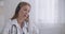 Health professional woman is consulting patients by telephone, using headphones with microphone, distant consultation