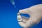 A health worker holding a syringe and a vial vaccine, getting it fill with  covid-19 vaccine first dose on a blue background