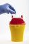 Health worker throws sharp waste into the medical waste bin. Medical waste bin pocket size 0,4 liter. Yellow biohazard medical