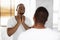 Healthcare Concept. Worried Black Man Touching Neck, Examining Lymph Nodes Near Mirror