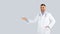 Healthcare and medical offer. Smiling middle aged man doctor in workwear pointing at free space for ad, panorama