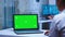Healthcare practitioner using laptop with green screen
