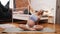 Healthcare during pregnancy. Smiling European pregnant girl sitting on a gray yoga mat and stretching her arms and side