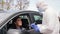 Healthcare worker with clipboard and woman in car