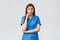Healthcare workers, prevent virus, insurance and medicine concept. Intrigued female doctor or nurse in blue scrubs