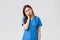 Healthcare workers, prevent virus and medicine concept. Tired sleepy female doctor, young nurse in blue scrubs, lean on