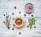 Healthful autumn hot herbal tea with berries, thyme and mint, jam from a rose, a spoon, a cut lemon, on a rustic wooden background