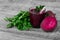 Healthful beet juice on a wooden background. Veggies on a desk. Fresh parsley foliage. Juicy beetroots full of vitamins.