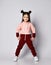 Healthy active brunette kid girl with buns in modern stylish pink brown sportswear stands with her legs wide apart