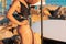 Healthy activity. A tanned woman in a swimsuit stands with a paddle in her hand, against the background of a sup board