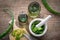 Healthy aloe vera, cutting board, mortar full of chopped aloe and bottles of aloe gel or infusion.