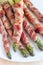 Healthy appetizer, green asparagus wrapped with bacon on white p