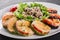 Healthy appetizer, grilled zucchini and eggplant with cheese with cheese on plate over black stone background.