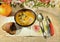 Healthy appetizer pumpkin soup sour cream seeds grains plate sandwich bread spoon folding knife gray background