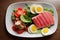 Healthy appetizing tuna salad with arugula leaves and scrambled eggs