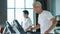 Healthy Asian senior couple exercise together in gym running treadmill