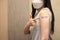 Healthy asian woman concept of recommended inoculation,  Woman holding down her shirt sleeve and showing her arm with bandage afte