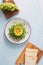 Healthy avocado toasts for breakfast or lunch with bread, sliced avocado, arugula, pumpkin and sesame seeds, salt and pepper.