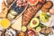 Healthy balanced breakfast on white background. Muesli, juice, croissants, cheese, biscuits and fruit, top view