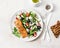 Healthy balanced lunch - grilled red fish fillet salmon and tomatoes, cucumbers, olives, feta Greek salad on a light background,