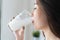 Healthy beautiful asian woman drinking plain fresh milk in the morning