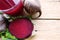 Healthy beet juice and raw beetroot on wooden table