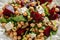 Healthy Beet Salad with chickpeas, pistachios nuts, feta cheese on rustic wooden background. close up